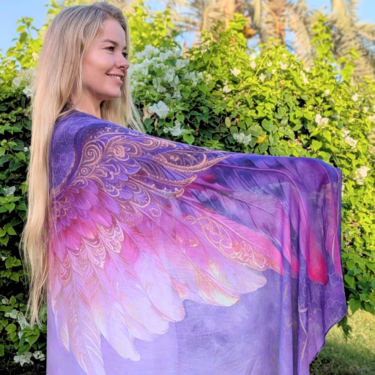 Happiness Shawl purple and pink angel wings with gold feather detail held open in the garden