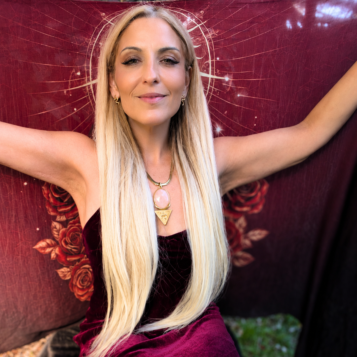 Woman in burgundy wearing the gold priestess necklace with rose quartz - sacred feminine jewellery