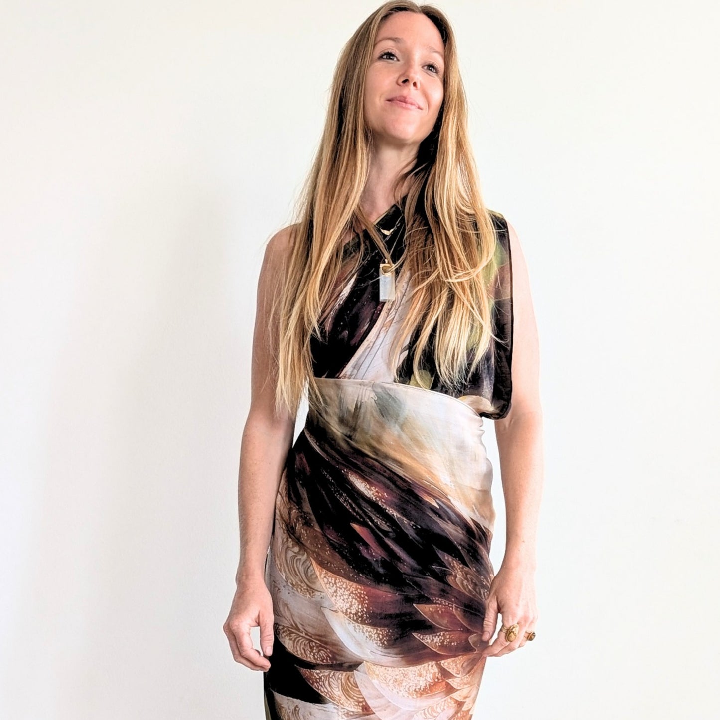 Woman wrapped in the Grounded Presence Shawl as a dress featuring angel wings and white lotus wearable wellness artwork