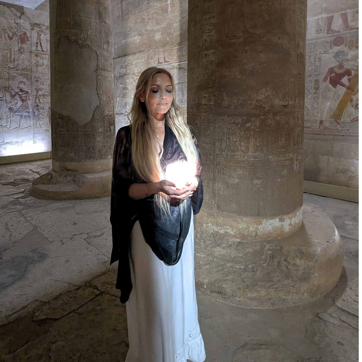 Strength Shawl worn as a brown angel wing wrap over a white dress inside an Egyptian temple