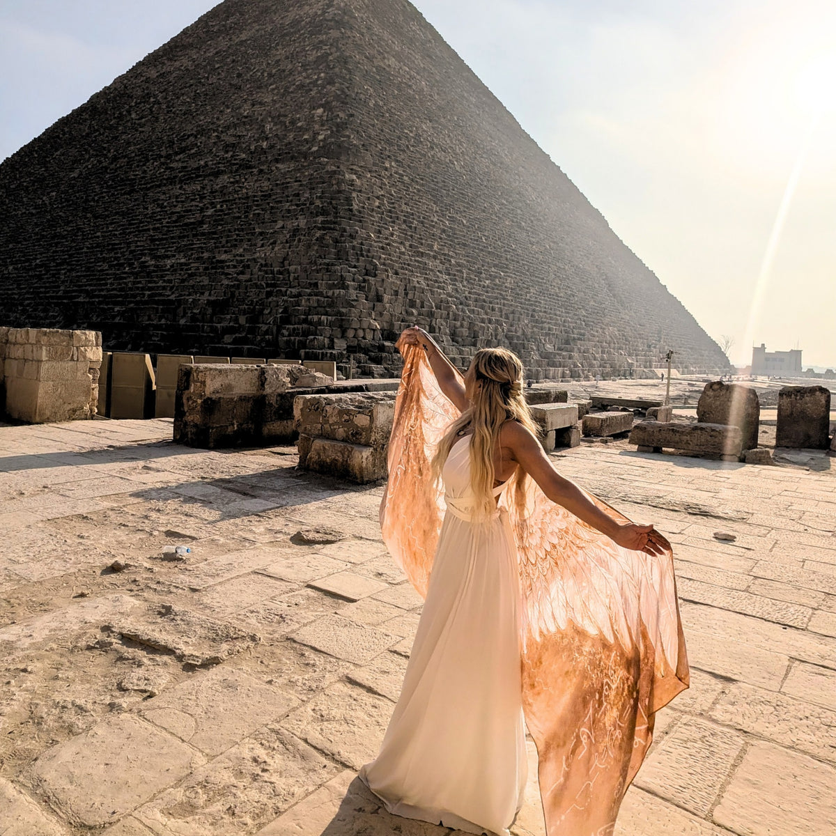 Safety Shawl gold and white angel wings spread open beside an Egyptian pyramid