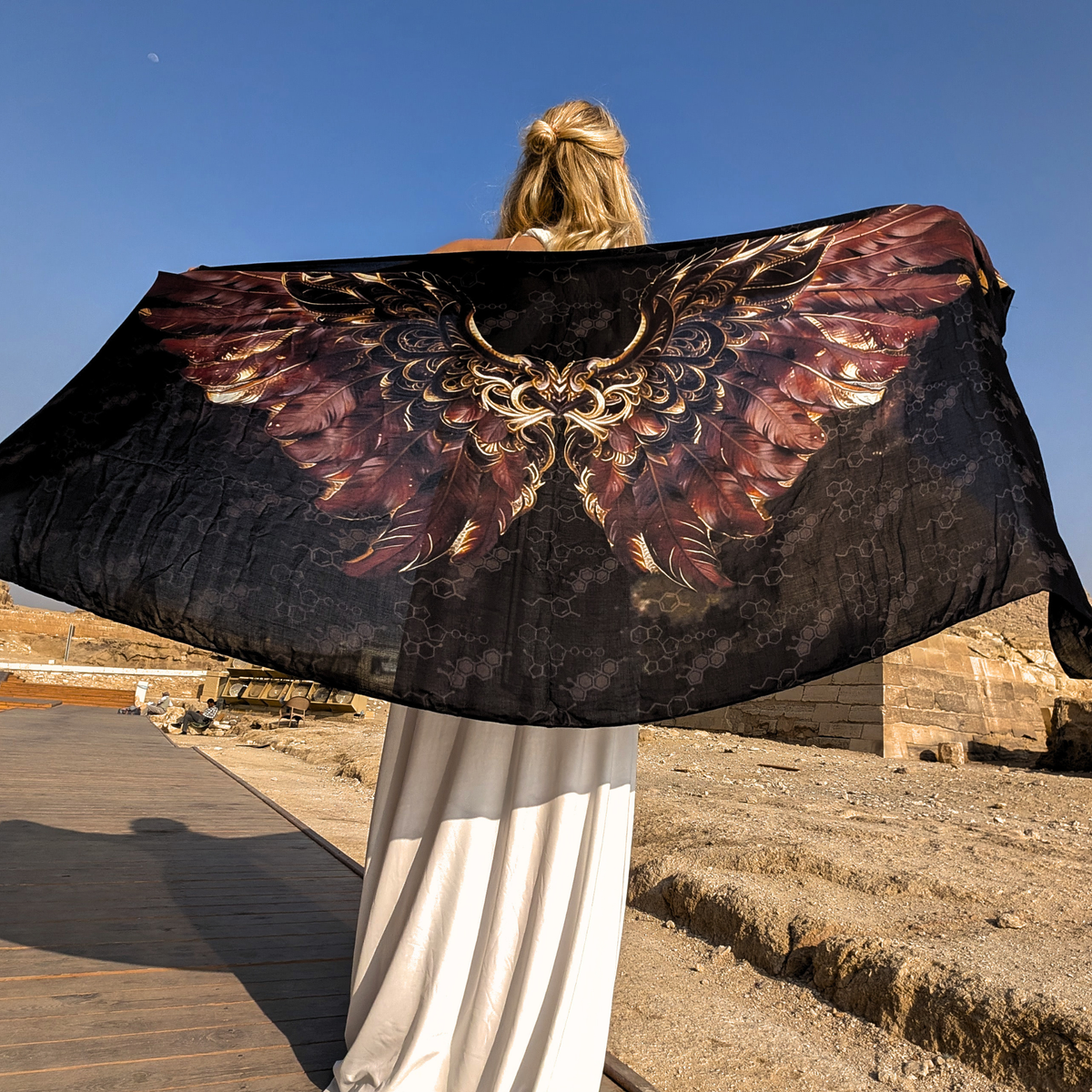 Back view of the Strength Shawl brown and gold angel wings spread wide in the Egyptian desert