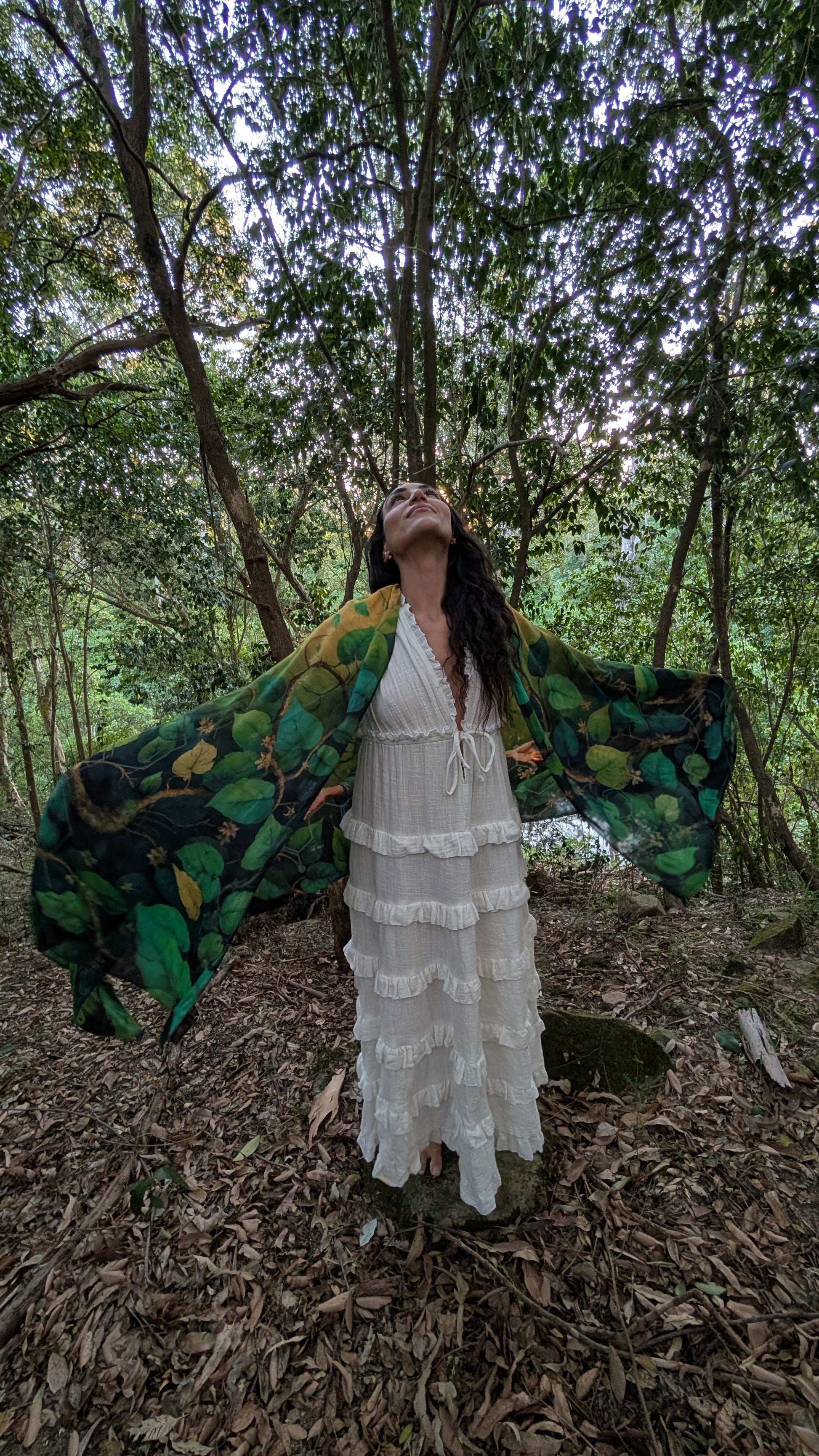Woman wearing the Grounded Presence Shawl tied as a kaftan, natural fabric clothing with Ayahuasca leaf print