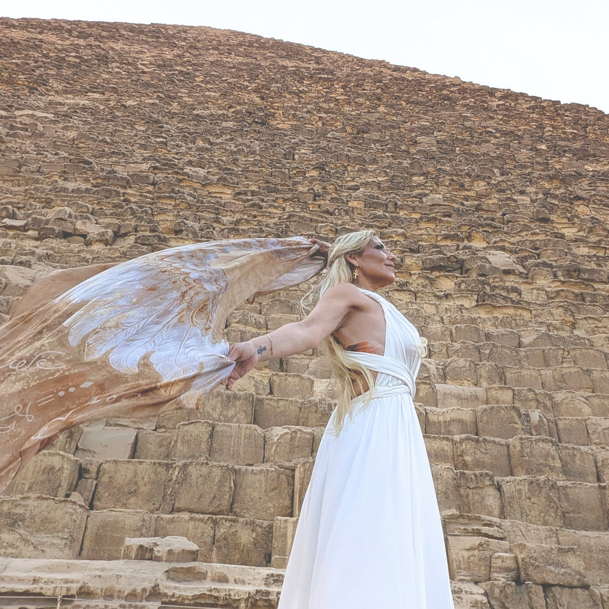Safety Shawl gold and white angel wings flowing in the wind at the Great Pyramid of Giza
