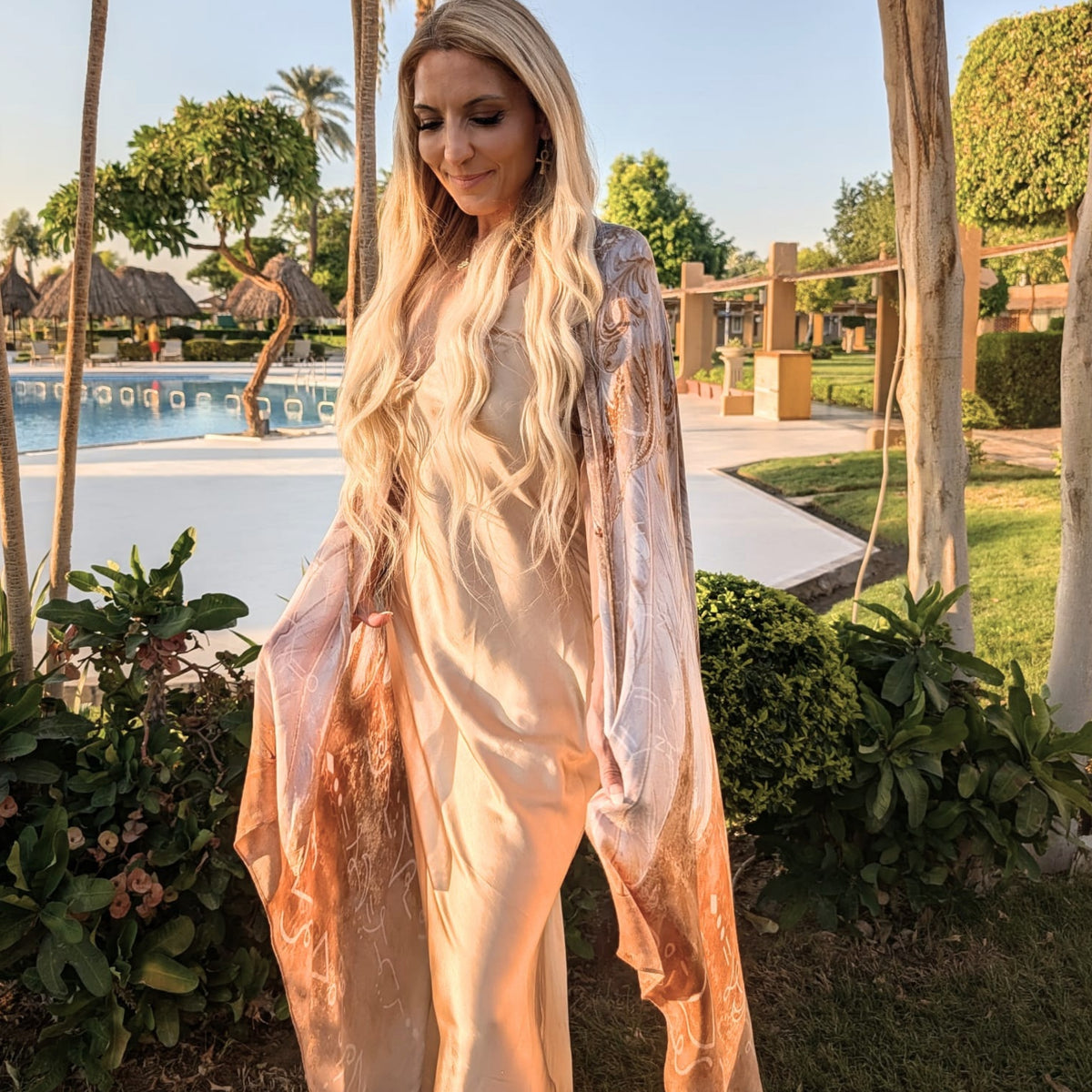 Safety Shawl worn as a flowing angel wing kimono over a champagne dress in a tropical garden
